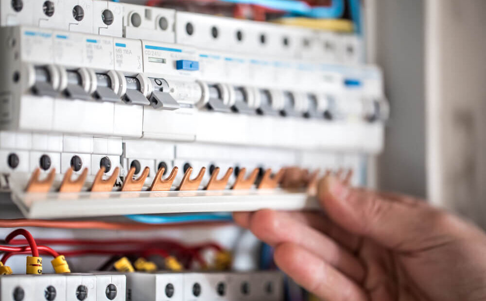 man-electrical-technician-working-switchboard-with-fuses-installation-connection-electrical-equipment-close-up (2) (1)
